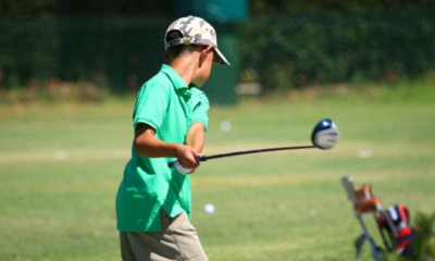 A young boy learning to play golf