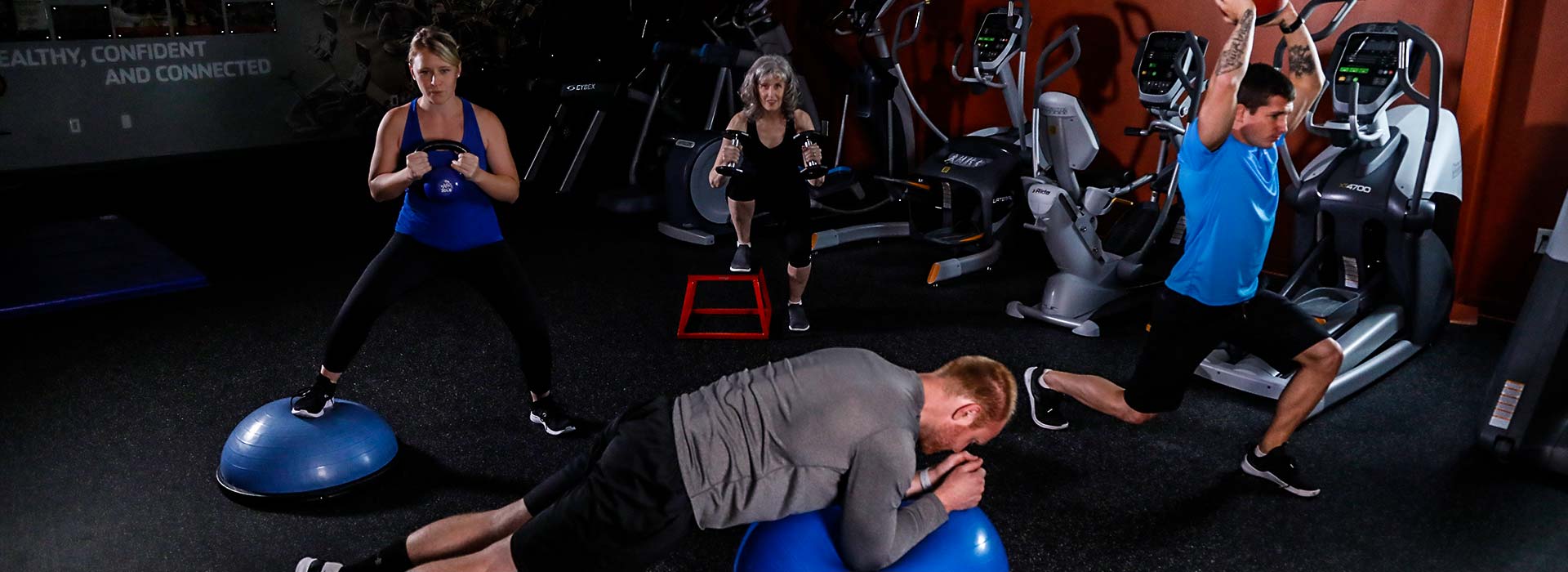 Group of friends in a group personal training session inside a gym at the YMCA
