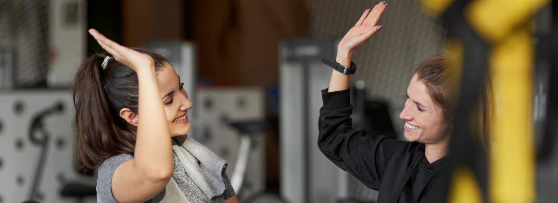 Two women at the gym, highfiving