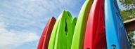 Row of colorful kayaks against a blue sky at YMCA Camp Arrowhead in Suffolk, Virginia