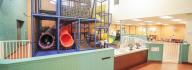 Child care play area including indoor climbing structure with slides
