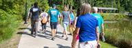 YMCA staff and donors have conversation while walking outside at YMCA at JT's Camp Grom