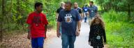 Camp donors walk along a path at YMCA Camp Red Feather
