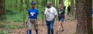 Camp donors walk along a trail at YMCA Camp Red Feather