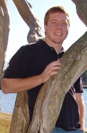 Photo of Paul Harris, with a tree in the foreground and water in the background