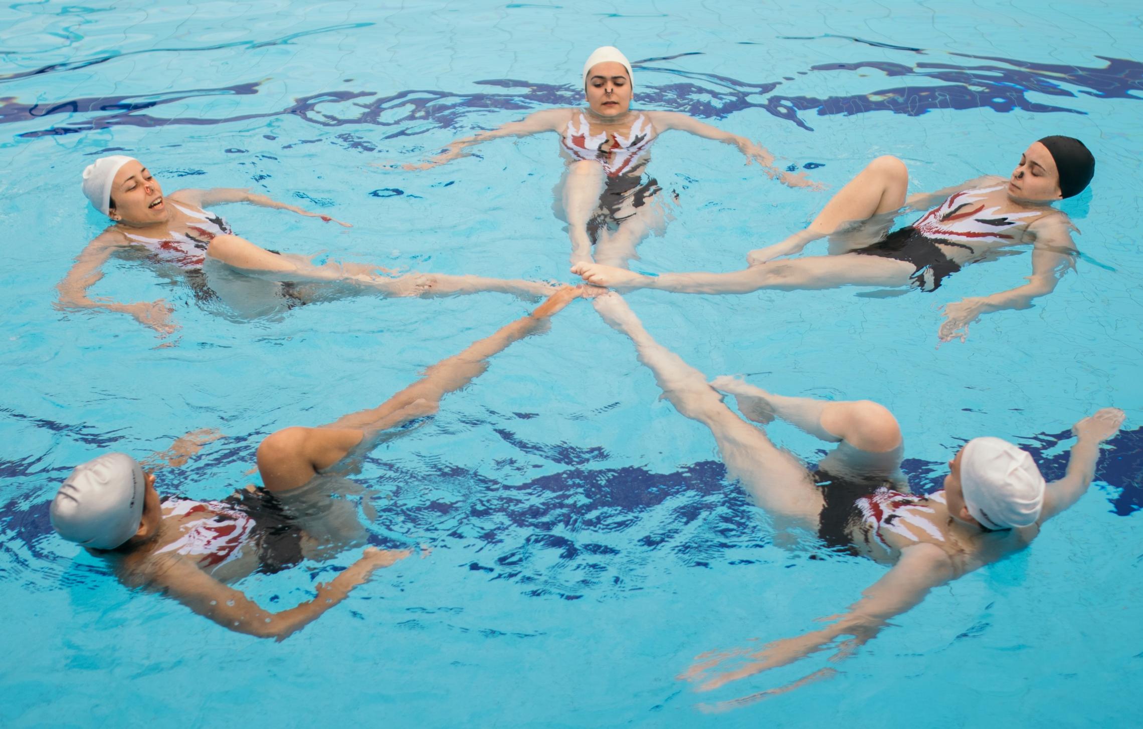 5 girls doing synchronized swimming