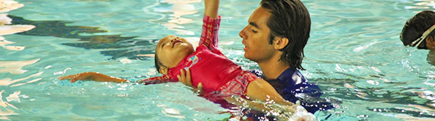 Y employee teaching child how to swim