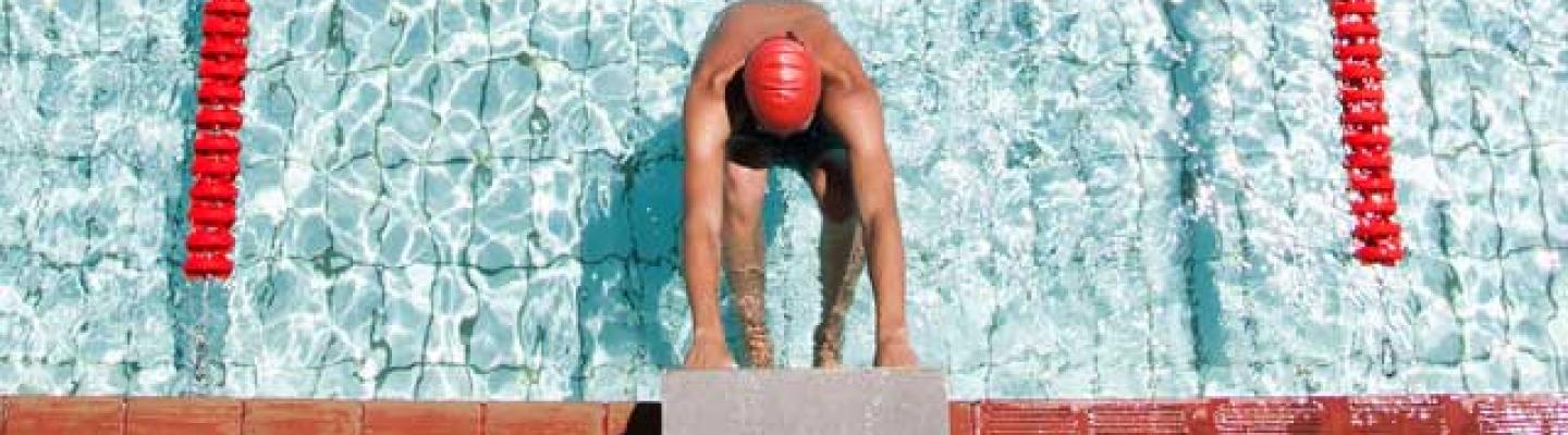 Competitive swimmer on the starting blocks waiting for the heat to begin