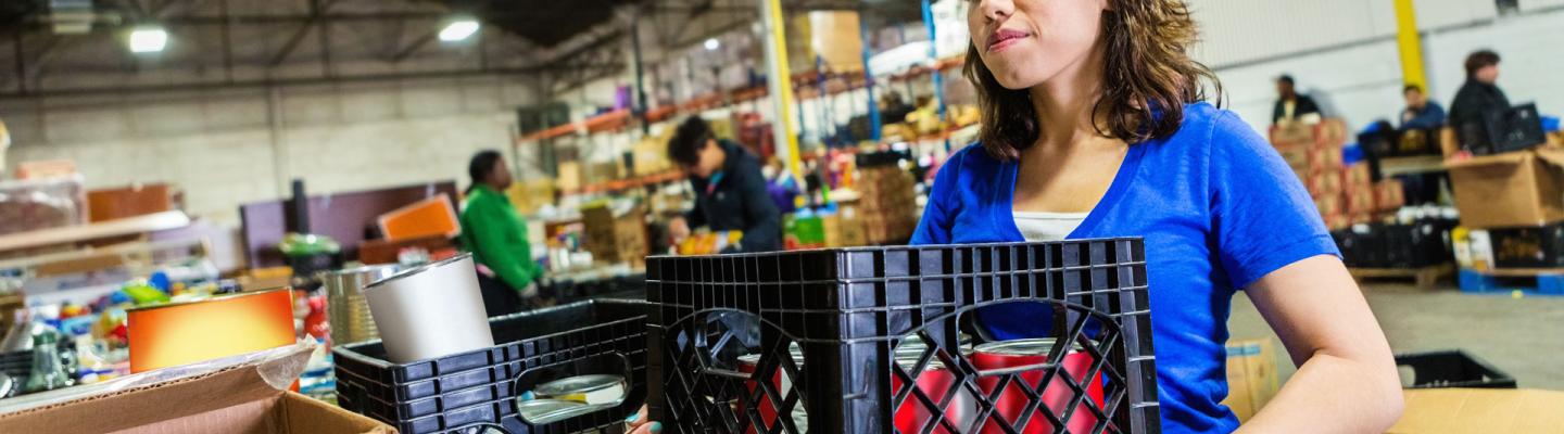 Volunteer holds crate of donated food