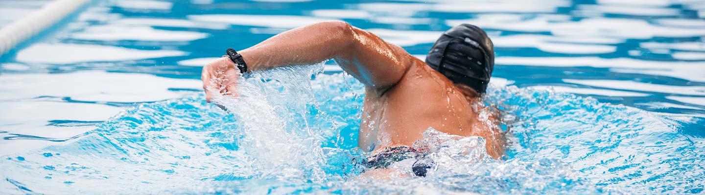 Man swims away in a swimming pool