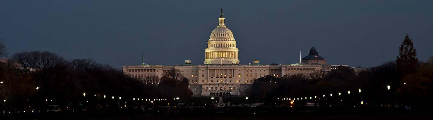 The US Capitol building lit against an evening sky