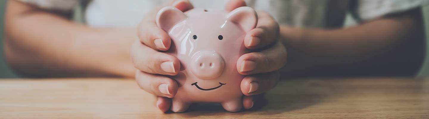 Young hands holding a piggy bank