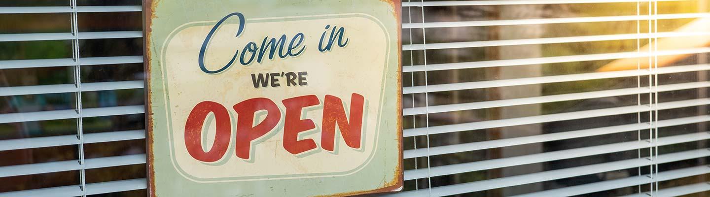 Window with a vintage sign that reads "Come in, we're open"