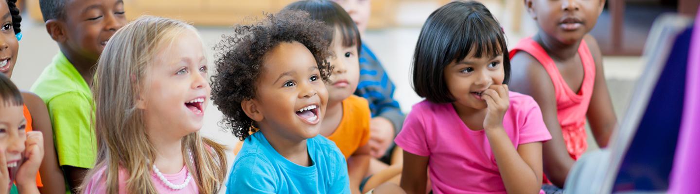 Group of preschoolers laughing during story time
