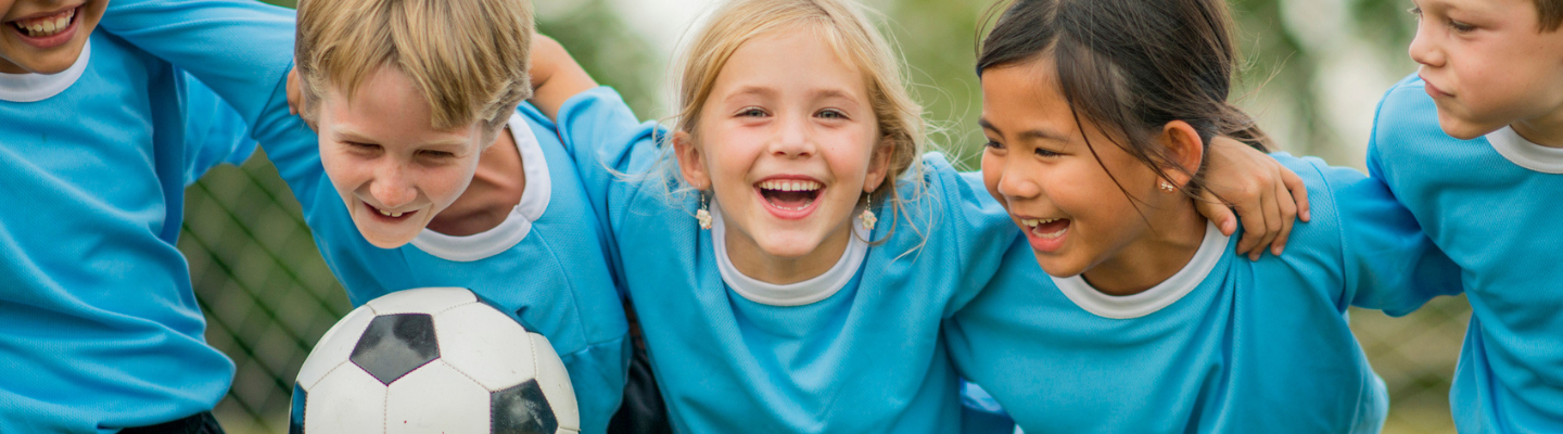 Children with their arms linked with a soccer ball