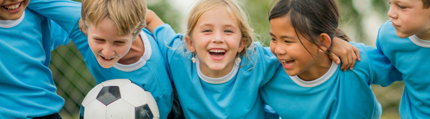 Children with their arms linked with a soccer ball 