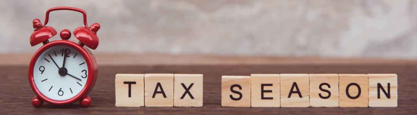 a red alarm clock next to scrabble letters that say tax season