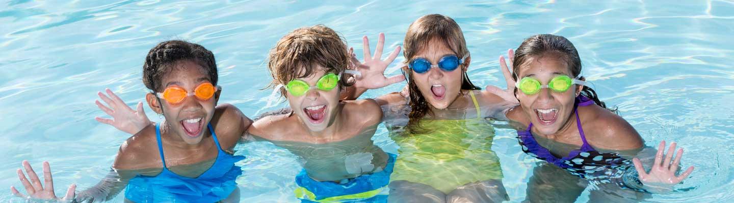 Kids gathered together posing in the outdoor pool