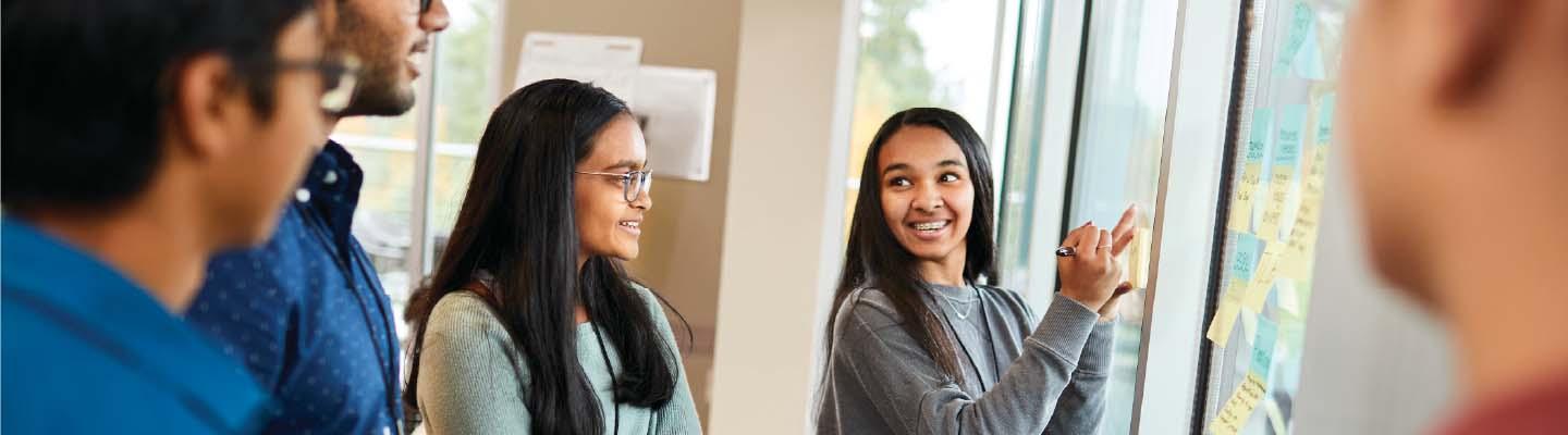 Teens working together brainstorming ideas on post-it notes