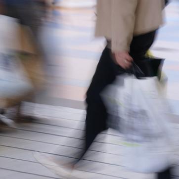 Blurred image of people walking on the street with shopping bags
