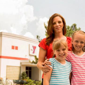 Mom with 2 kids in front of a YMCA center