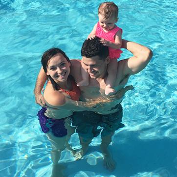 Family in the YMCA outdoor pool with child on dad shoulders