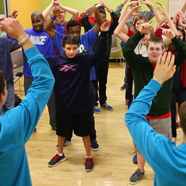 large group of kids raising arms in a fitness class