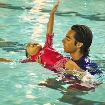 Y employee teaching child how to swim