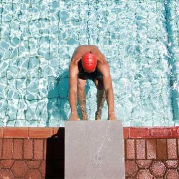 Competitive swimmer on the starting blocks waiting for the heat to begin