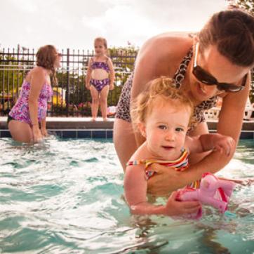 Mom with toddler age daughter in outdoor swimming pool