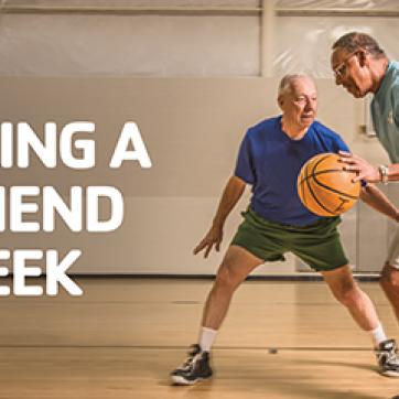 Two Older men playing basketball in an indoor gym with text "Bring a Friend Week"