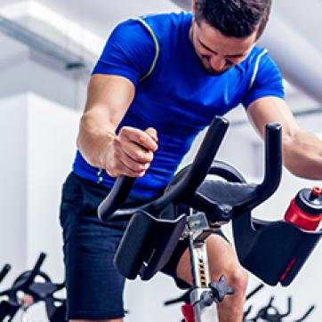 Man in blue shirt on a stationary cycle bike