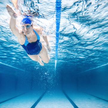woman under water doing a lap in the pool