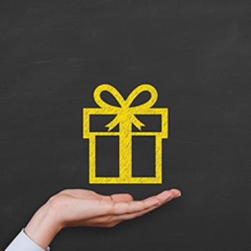 black background image with a hand holding a present box