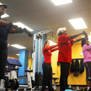 YMCA members working out with free weights in the fitness center