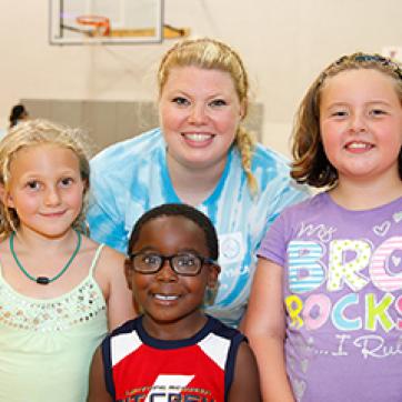YMCA child care staff with kids in the gym