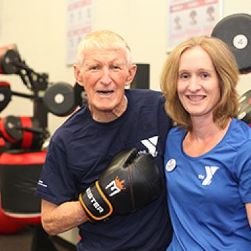 Senior male with YMCA trainer in boxmaster class