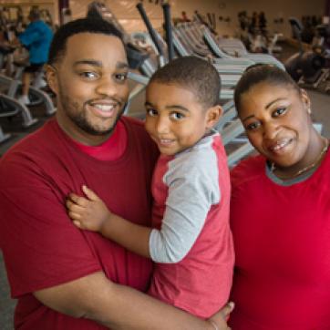 African American family posing and smiling in a fitness center