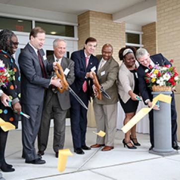 Ribbon cutting ceremony outside the front lobby of a building