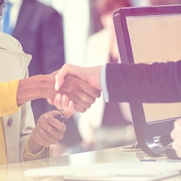 People shaking hands over a counter