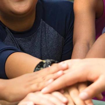 A group of campers putting hands together in teamwork