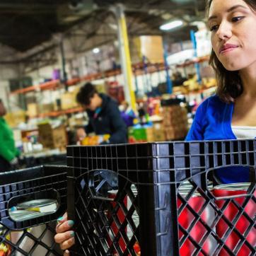 Volunteer holds crate of donated food