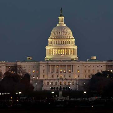 The US Capitol building lit against an evening sky