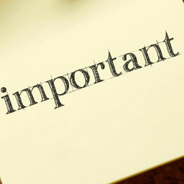 Corkbord with sticky note pinned with message "Important" on the sticky. note