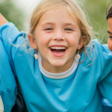 Children with their arms linked with a soccer ball 