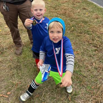 Tommy Mras and Mack O'Connor holding their soccer medals