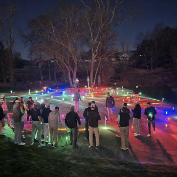 Golfers on putting green with glowing golf balls all over green