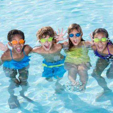 Kids gathered together posing in the outdoor pool