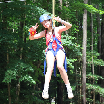 One girl on the zip line smiling at the camera