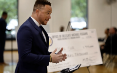 Del. Michael Feggans presents a ceremonial check to the YMCA of South Hampton Roads which will help launch a groundbreaking initiative that will make high-quality child care more affordable and accessible for educators in Virginia Beach’s Title I schools on Monday, Sept. 29, 2025. (Stephen M. Katz / The Virginian-Pilot)